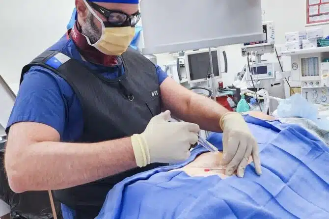 Image of Dr. Abdallah injecting steroids to relieve pain.
